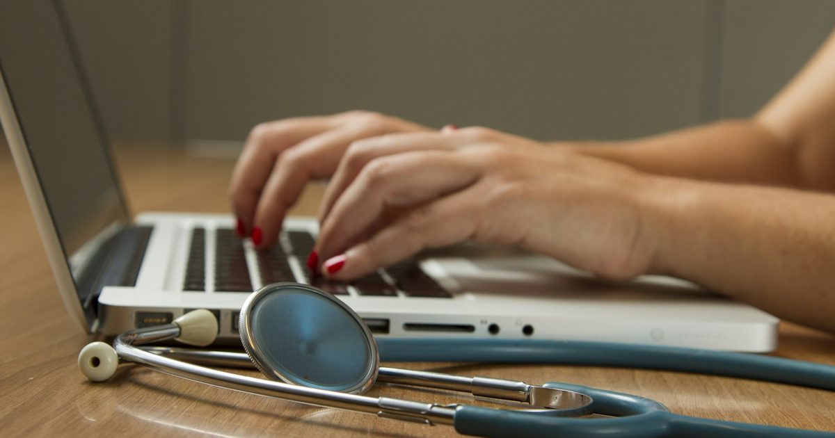 A CareGiver documenting clinical observations on a digital tablet during a home visit