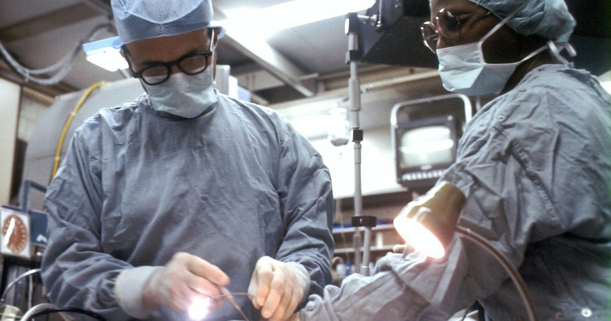 A patient recovering at home after surgery while a CareGiver checks vital signs