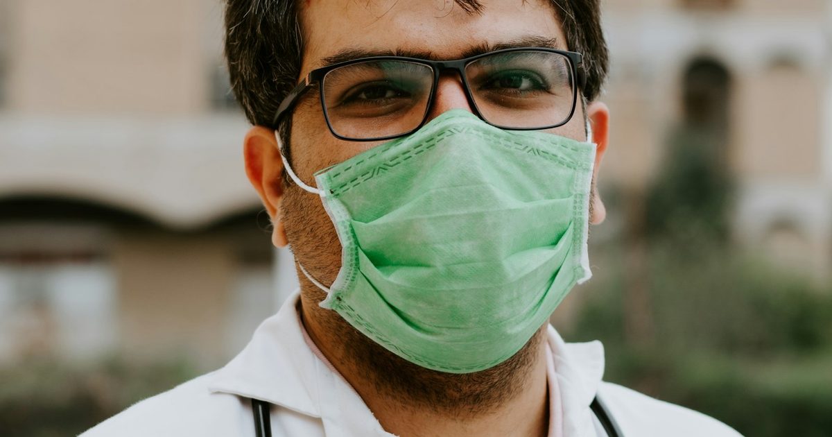 A confident professional CareGiver in uniform smiling — flexible home care work on SoftCare